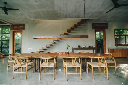 a dining room with a large wooden table and chairs at ZIN Berawa Villas & Bungalows in Canggu
