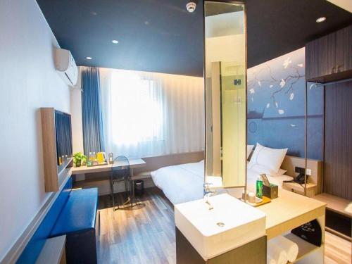 Un ou plusieurs lits dans un hébergement de l'établissement Magnotel Business Yixing Passenger Station Tuanjiu Scenic Area