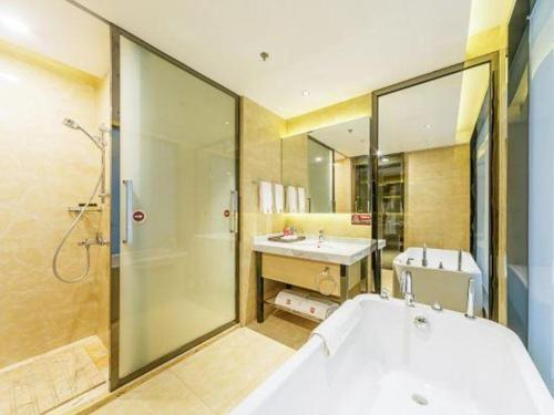 a bathroom with a tub and a shower and a sink at Zhongshan Da Dong Yu Hotel in Zhongshan
