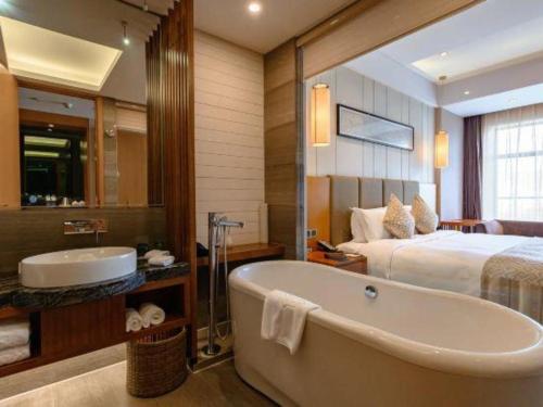 a bathroom with a bath tub and a bed at Suzhou Qingshan Conference Center in Suzhou