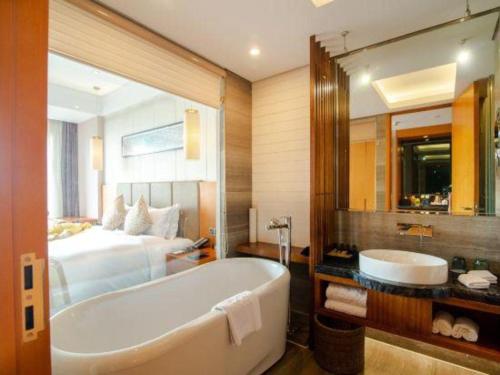 a bathroom with a bath tub and a bed at Suzhou Qingshan Conference Center in Suzhou