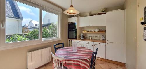 una cocina con mesa y sillas y una cocina con ventanas en Maison Josephine, en Kervoz
