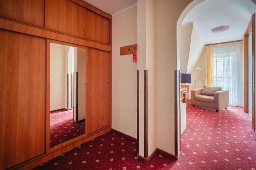 a corridor of a room with a door and a couch at Kompleks Antałówka Termy & Med in Zakopane
