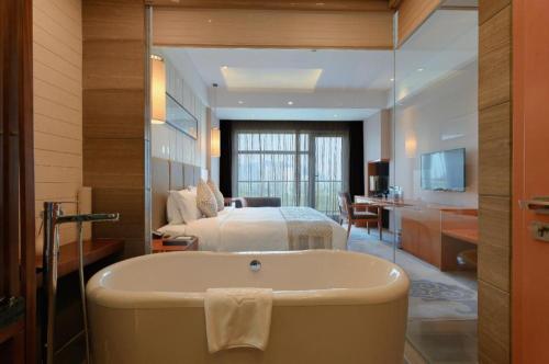 a bathroom with a bath tub and a bedroom at Suzhou Qingshan Conference Center in Suzhou