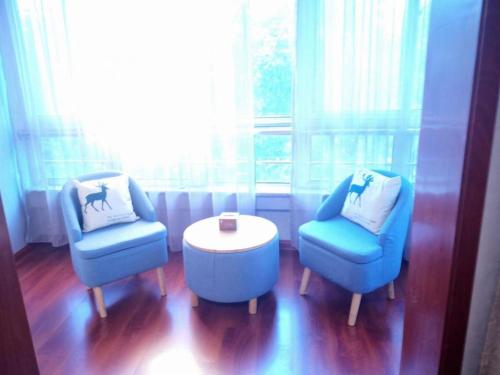 two chairs and a table in a room with a window at PAI Hotels·Shijiazhuang Development Zone Tianshan Science and Technology Park in Shijiazhuang