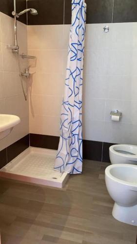 a bathroom with a toilet and a shower curtain at La Masseria Hotel Ristorante Centro Benessere in Cocumola