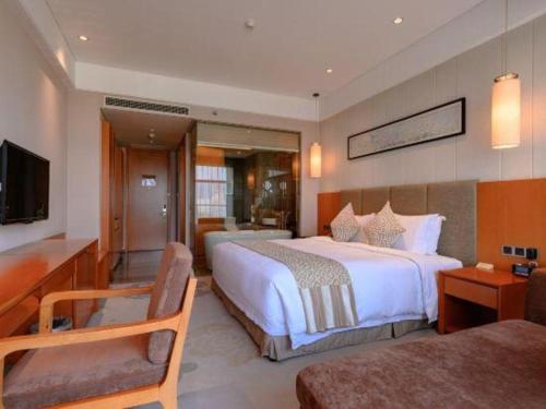 a hotel room with a large bed and a television at Suzhou Qingshan Conference Center in Suzhou