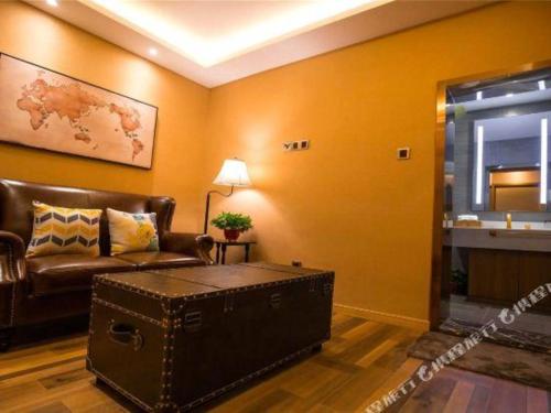 a living room with a leather couch and a table at James Joyce Coffetel·Kaifeng Drum Tower in Kaifeng
