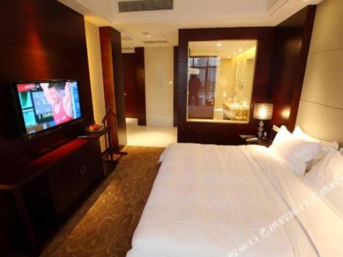 a hotel room with a bed and a television at Suzhou Qingshan Conference Center in Suzhou