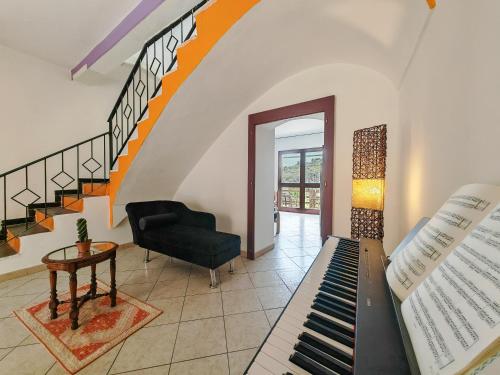 a living room with a piano and a staircase at Sa Posada in Cuglieri