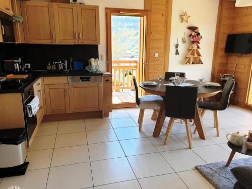 - une cuisine avec une table, une table et des chaises dans l'établissement Résidence Appaloosa - Appartement cosy dans petite résidence MAE-3451, aux Gets