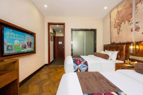 a hotel room with two beds and a tv at James Joyce Coffetel·Lijiang Old Town Centeral in Lijiang