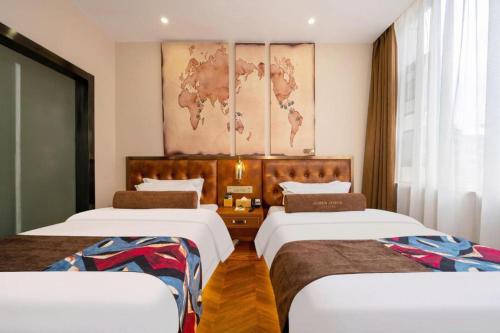 a hotel room with two beds and a map on the wall at James Joyce Coffetel·Lijiang Old Town Centeral in Lijiang