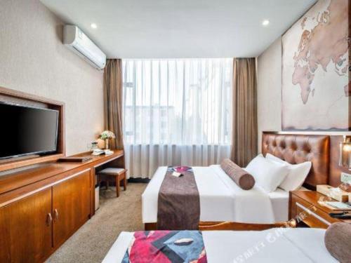 a hotel room with a bed and a flat screen tv at James Joyce Coffetel·Lijiang Old Town Centeral in Lijiang
