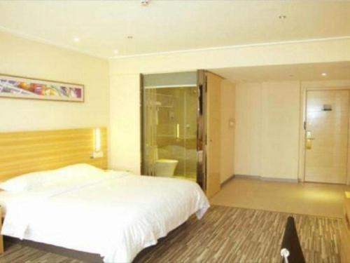 a bedroom with a white bed and a bathroom at City Comfort Inn Qianjiang Longxiacheng in Qianjiang