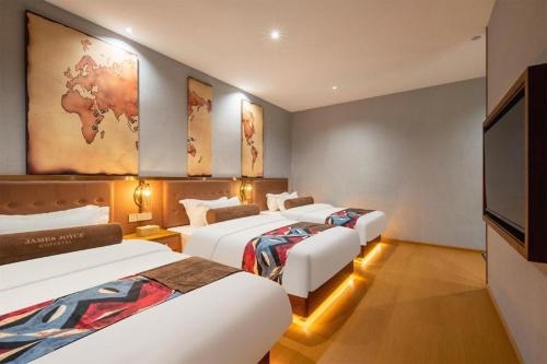 a hotel room with three beds and a flat screen tv at James Joyce Coffetel·Lijiang Old Town Centeral in Lijiang