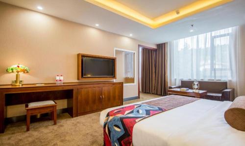 a hotel room with a bed and a flat screen tv at James Joyce Coffetel·Lijiang Old Town Centeral in Lijiang