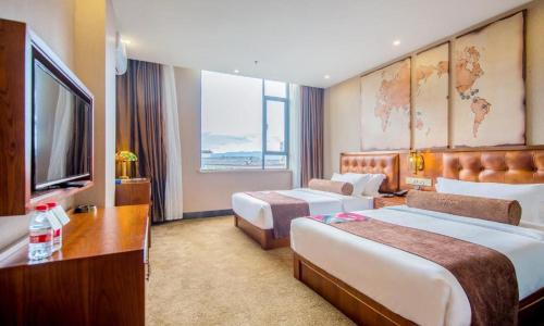 a hotel room with two beds and a television at James Joyce Coffetel·Lijiang Old Town Centeral in Lijiang
