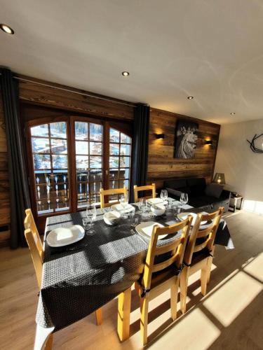 une salle à manger avec une table et des chaises noires dans l'établissement Résidence Helios - Appartement 2 chambres - vue splendide MAE-1111, aux Gets