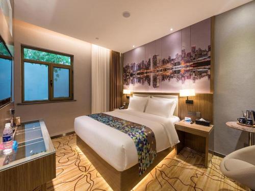 a hotel room with a large bed and a desk at ZMAX Hotel Beijing Tongzhou Universal Tourist Resort Linheli Metro Station in Liyuanzhen