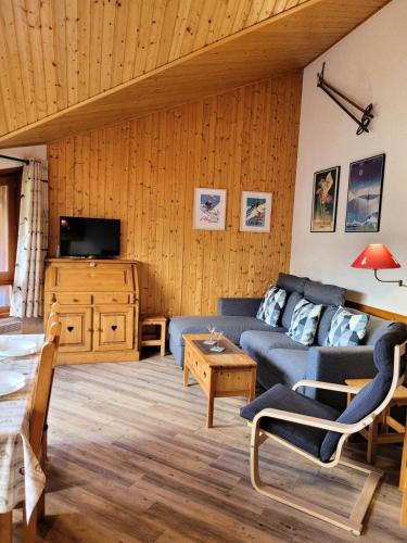 un salon avec un canapé bleu et une télévision dans l'établissement Résidence La Bouillandire - Appartement lumineux avec vue imprenable MAE-1121, aux Gets