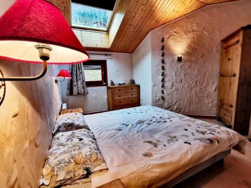 - une chambre avec un lit et une lampe rouge dans l'établissement Résidence La Bouillandire - Appartement lumineux avec vue imprenable MAE-1121, aux Gets