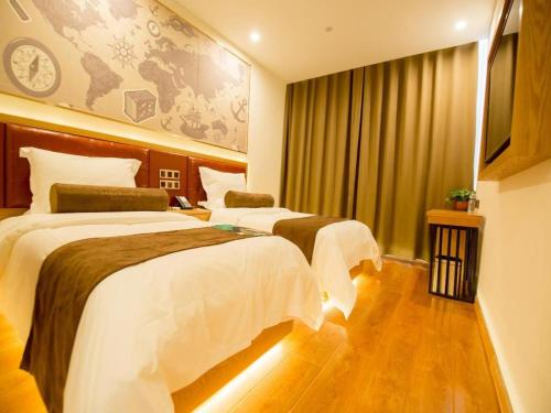 a hotel room with two beds and a clock on the wall at James Joyce Coffetel Harbin Central Street in Harbin