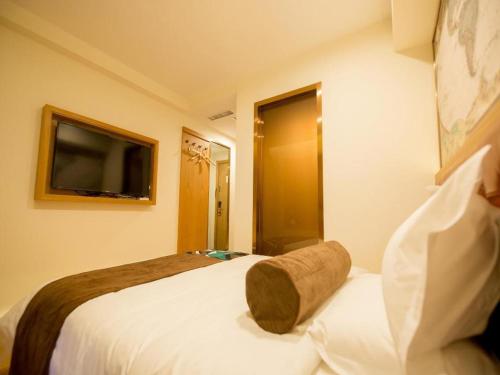 a hotel room with two beds and a television at James Joyce Coffetel Harbin Central Street in Harbin