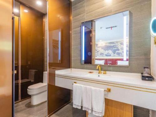 a bathroom with a sink and a toilet and a window at James Joyce Coffetel Harbin Central Street in Harbin