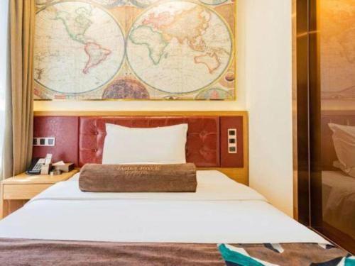 a bedroom with a bed with a map on the wall at James Joyce Coffetel Harbin Central Street in Harbin