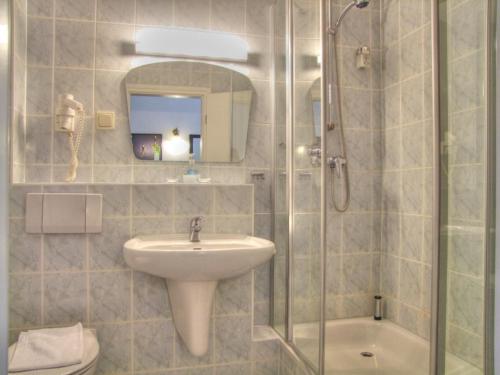 a bathroom with a sink and a glass shower at Hotel Gastmahl des Meeres in Sassnitz