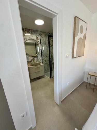 a bathroom with a mirror and a sink at Apartments Toma in Novalja