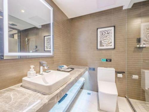a bathroom with a sink and a mirror at Xana Hotelle Zhuhai Gongbei Port in Zhuhai