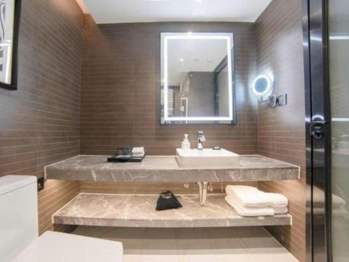 a bathroom with a sink and a mirror at Xana Hotelle Zhuhai Gongbei Port in Zhuhai
