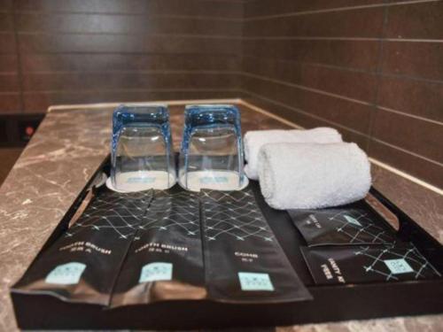 a tray with two glasses and towels on a table at Xana Hotelle Zhuhai Gongbei Port in Zhuhai