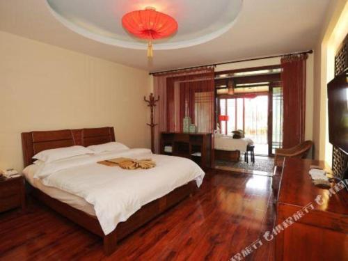 a bedroom with a large bed and a chandelier at Kunming Dianchi Garden Hotel & Spa in Kunming