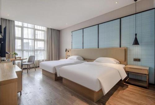 Ένα ή περισσότερα κρεβάτια σε δωμάτιο στο Echarm Hotel Baise Sports Center Dream Island Plaza