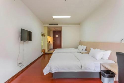 a hotel room with two beds and a television at Guangzhou Hailian Hotel - Haizhu District Binjiang East Road Metro Station in Guangzhou