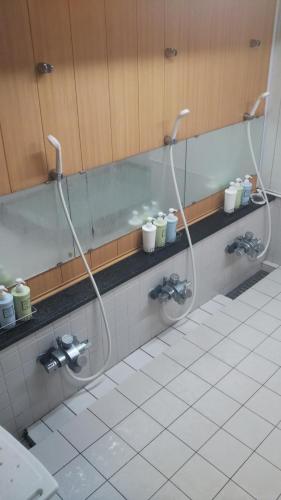 a bathroom with two shower heads on a wall at Kikunoya Ryokan in Kanazawa