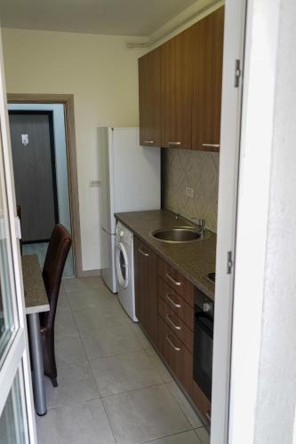 a small kitchen with a sink and a refrigerator at Skyline Apart 2 Militari Residence in Roşu