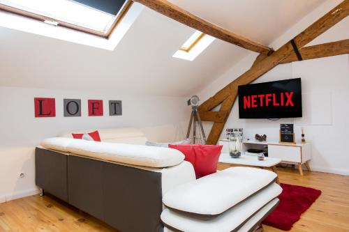 un salon mansardé avec un canapé blanc et des coussins rouges dans l'établissement LB Vacation Rentals I Big Loft 107m2, 10min Walk to Palais des Festivals, à Cannes