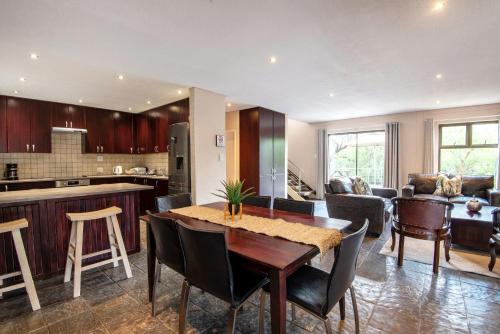 a kitchen and living room with a table and chairs at Arebbusch Travel Lodge in Windhoek