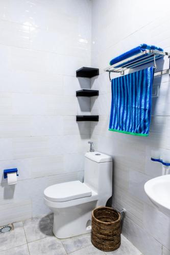 a white bathroom with a toilet and a sink at Maison Ubururu in Kigali