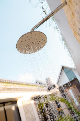 a shower head with water on a window at Guna Villas in Dalung