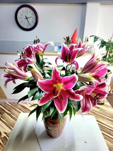 a vase filled with pink flowers on a table at Yen Minh Resthouse in Ho Chi Minh City