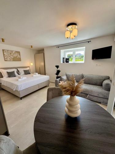 a living room with a bed and a table at Apartments Toma in Novalja