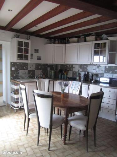 une cuisine avec une table et des chaises en bois dans l'établissement Maison dans le Beaujolais vert, à Thizy-les-Bourgs