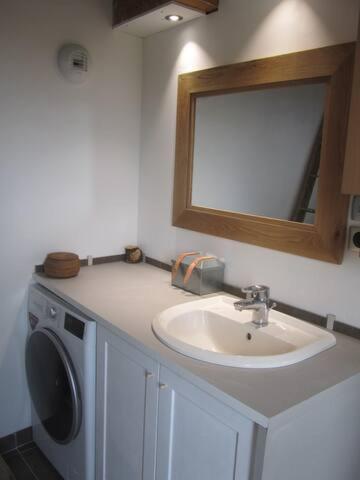 une salle de bain avec un lavabo et une machine à laver dans l'établissement Maison dans le Beaujolais vert, à Thizy-les-Bourgs