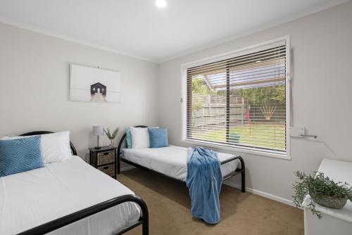 a bedroom with two beds and a window at Banksia in Rosebud