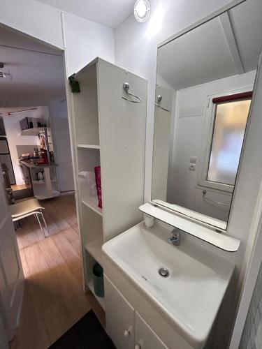 une salle de bain blanche avec un lavabo et un miroir dans l'établissement Mobile-home aux Cigales Le Muy 4-6 Personnes,Exterieur XXL pergola ,veranda salon jardin, au Muy